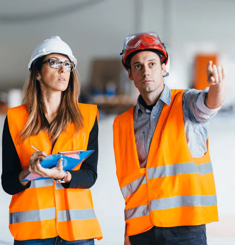 safety inspector checking building exterior with tablet for code compliance